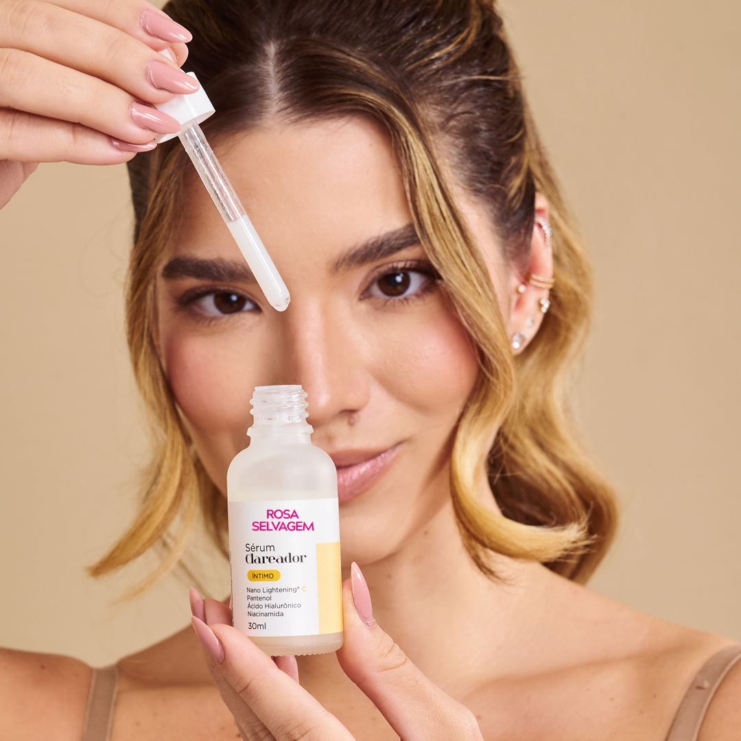 Mulher aplicando sérum Rosa Selvagem com conta-gotas